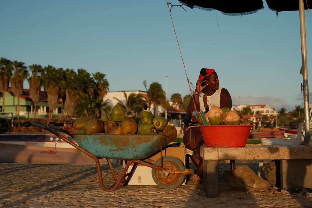 Vendedor de cocos na praia ao pôr do sol