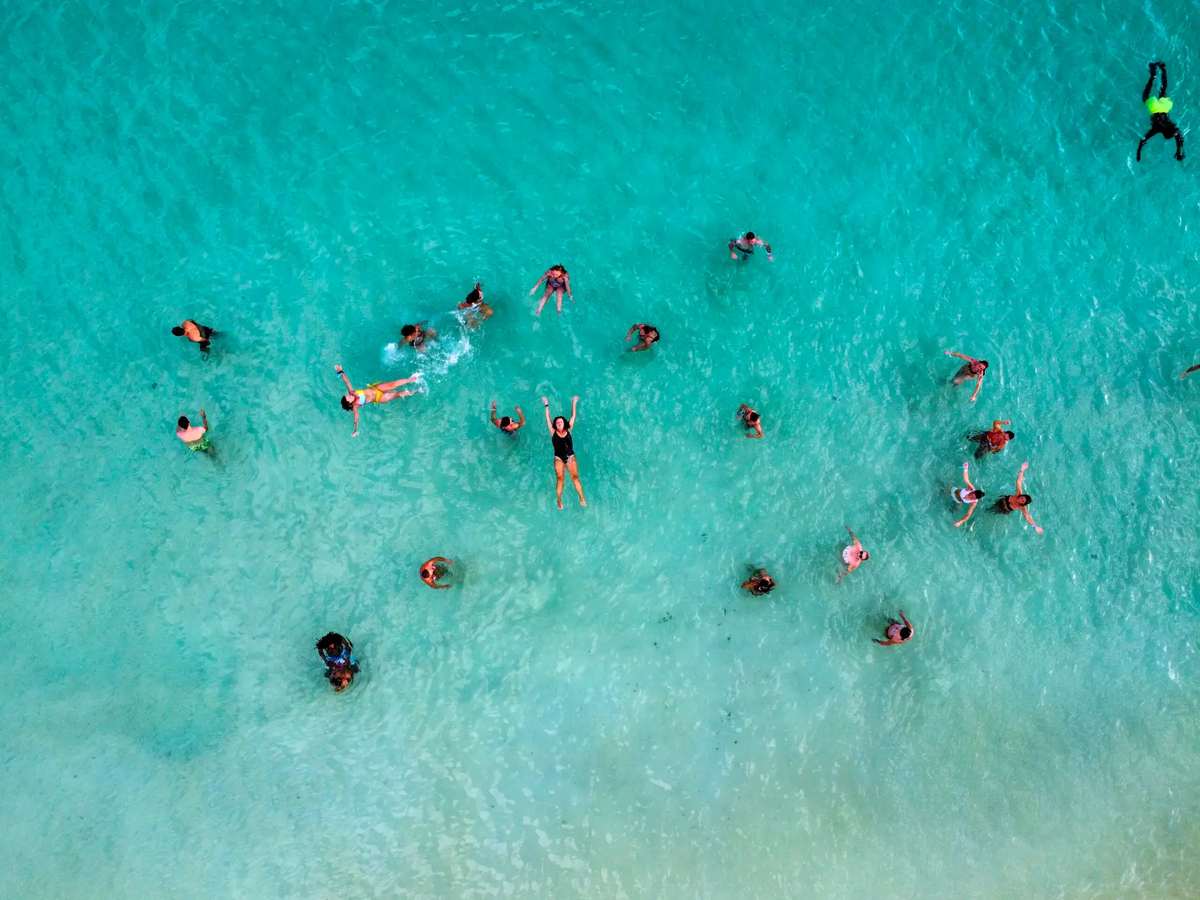 Vista aérea de banhistas em águas turquesa na Ilha do Sal